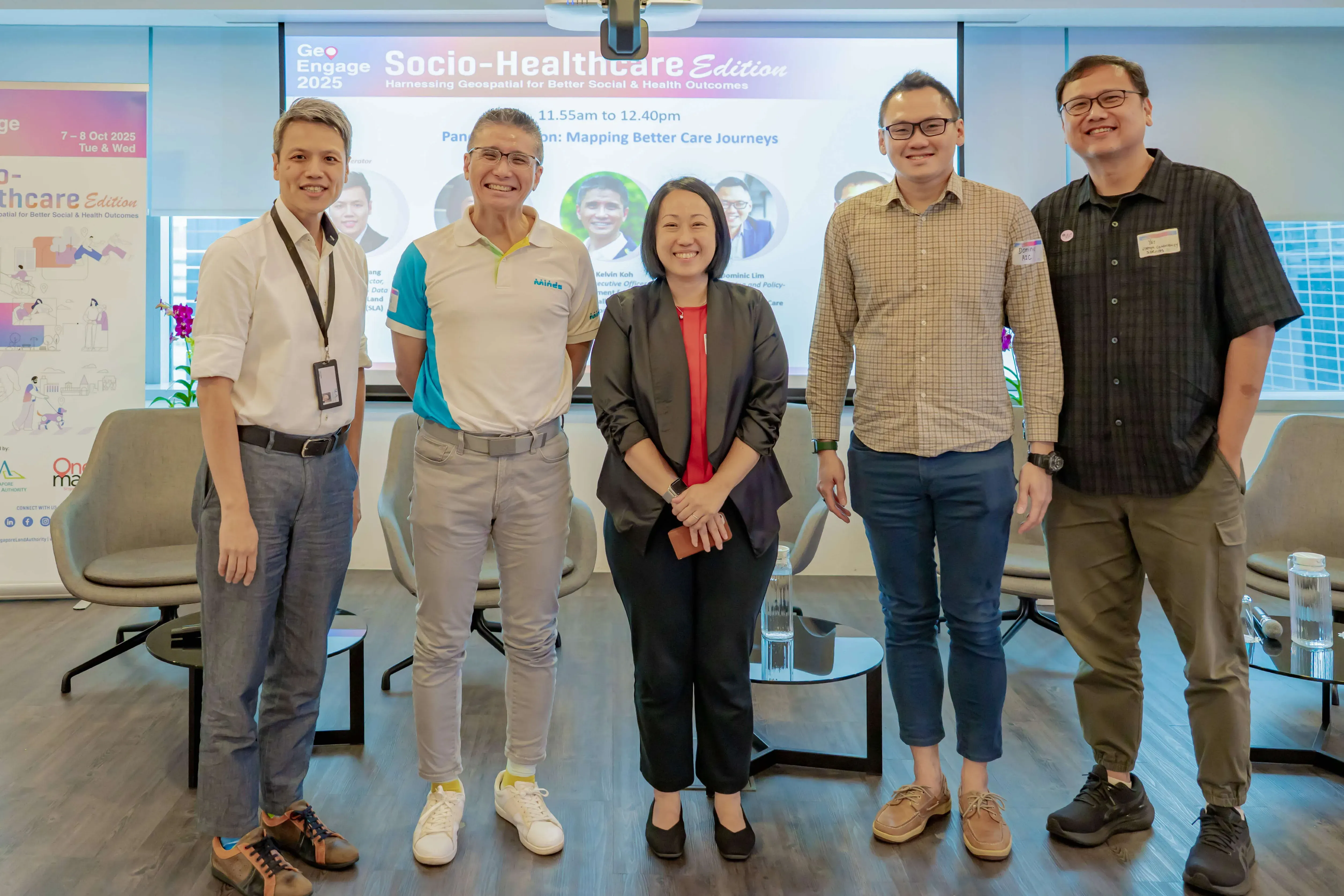 Five people pose smiling at GeoEngage 2025 Socio-Healthcare Edition panel discussion on Mapping Better Care Journeys.